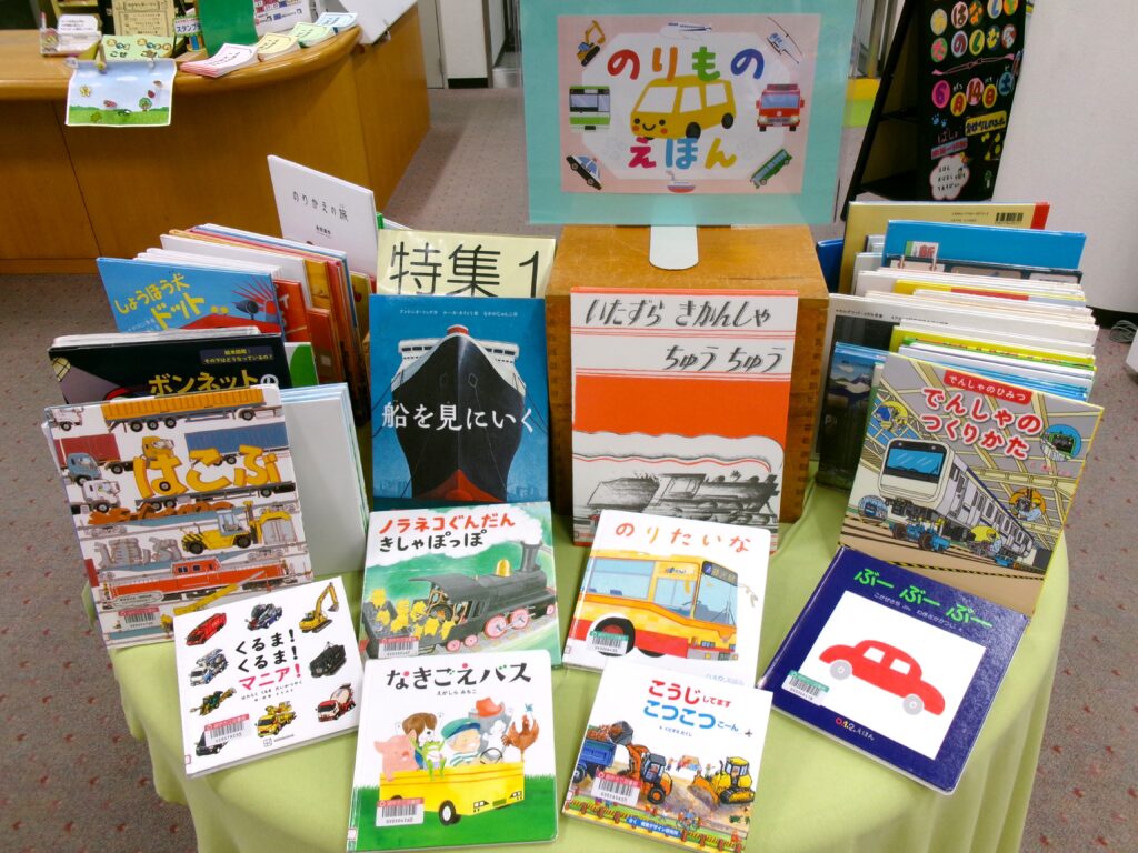 特集コーナーの裏側の写真。「のりものえほん」POPと、「ノラネコぐんだん きしゃぽっぽ」などの表紙を見せた絵本がテーブルにある。