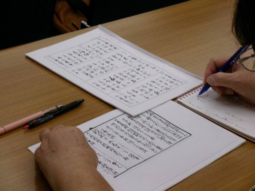 講座の画像。参考資料を見ながらノートを取る参加者の様子。