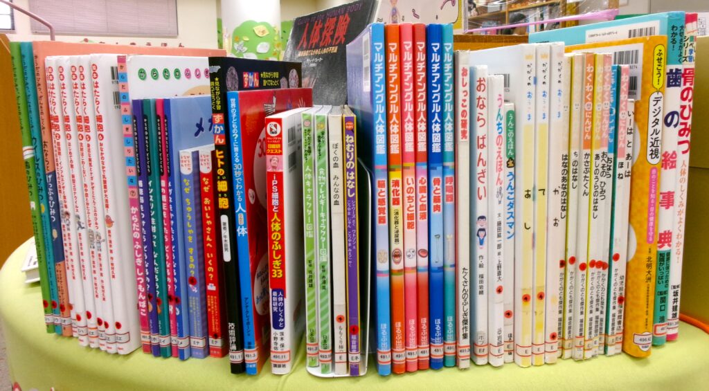 特集本の画像。「絵本はたらく細胞」「マルチアングル人体図鑑」「おならばんざい」「骨のひみつ」などの本が並ぶ。